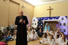 Kardynał Kazimierz Nycz przemawia. W tle uczniowie szkoły.